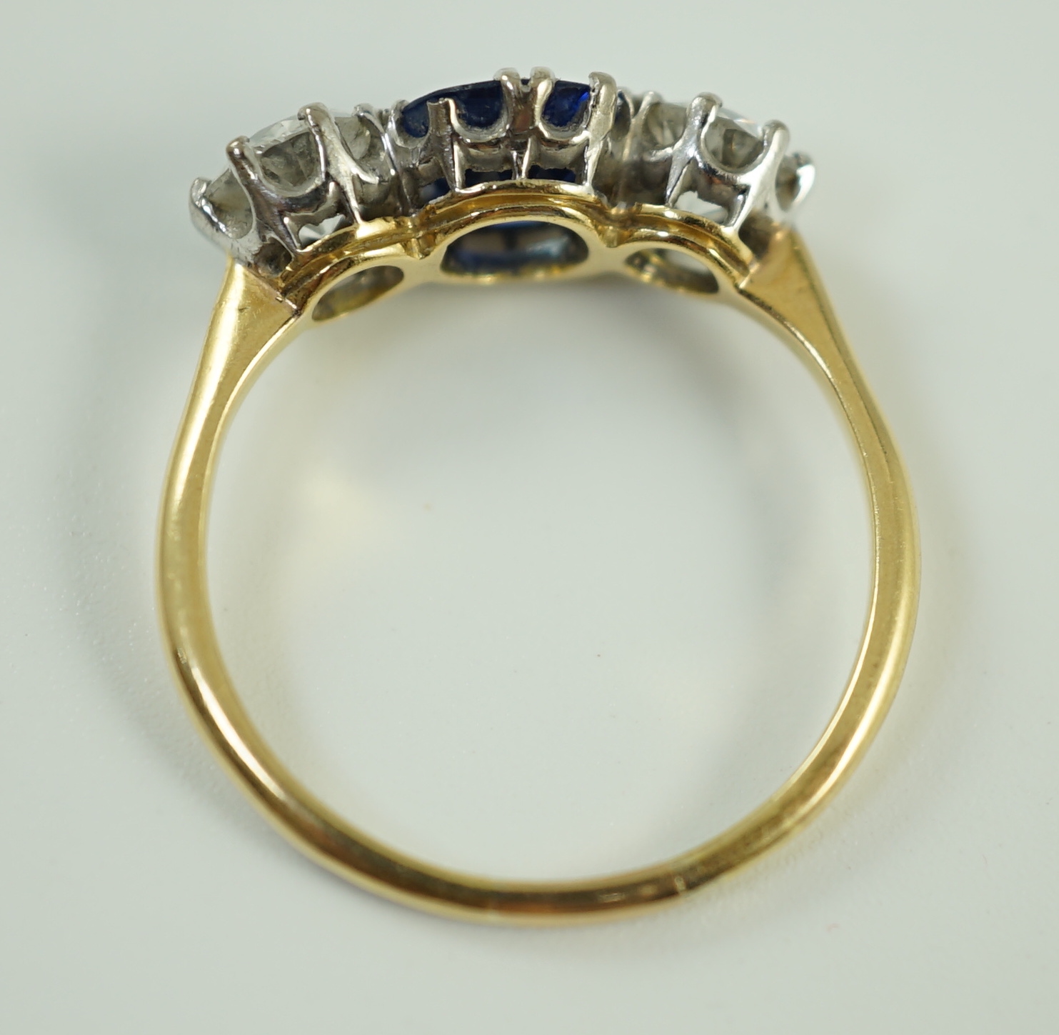 An 18ct gold, single stone oval cut sapphire and two stone round cut diamond set ring